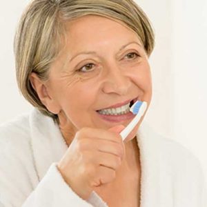 Senior woman brushing teeth
